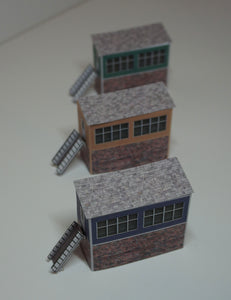 3 N Gauge signal boxes of different colours viewed from above
